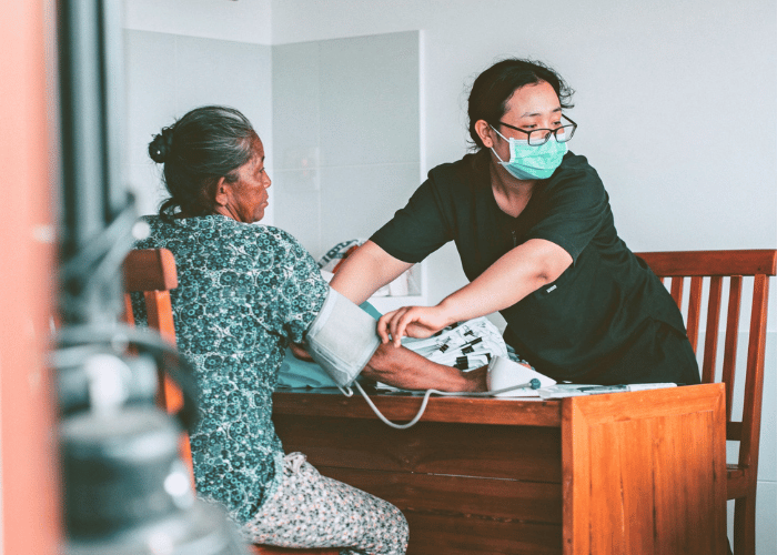 Arzthelferin misst Blutdruck bei einer Patientin
